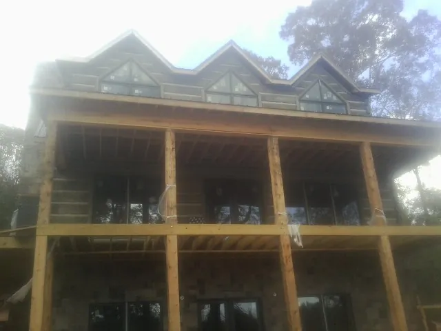 Dormers and porch framing on a large log home under construction — Roof Coating work by our crew in Prosser